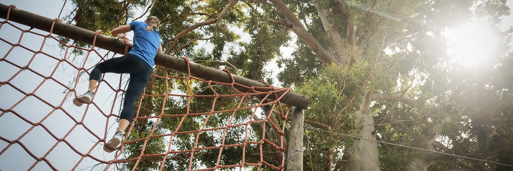 Woman climbing tall net