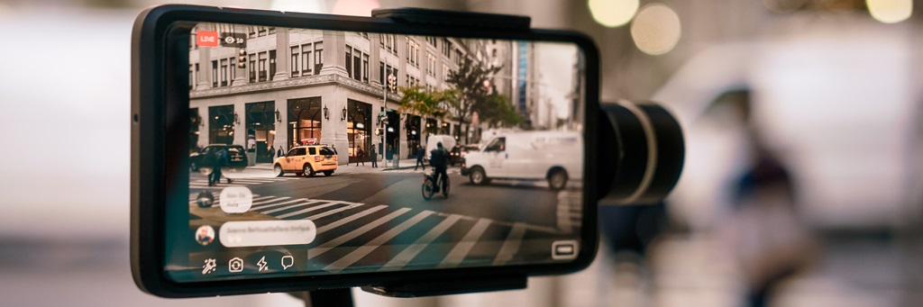 Man using phone with stabilizer and taking pictures and live video in New York city. Vlog, video blogging, street photography concept.